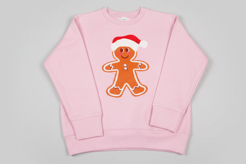 Pink sweatshirt with a gingerbread man design on a gray background