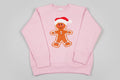 Pink sweatshirt with a gingerbread man design on a gray background